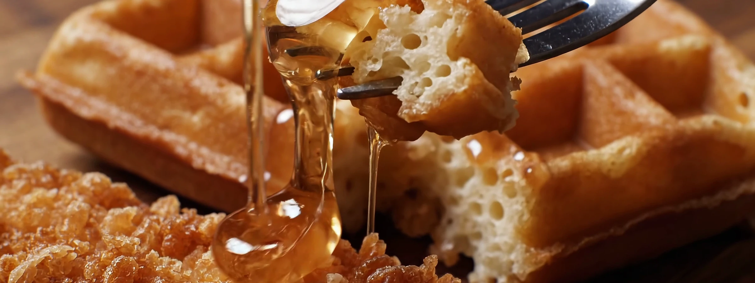 A fork pressing into a fresh waffle